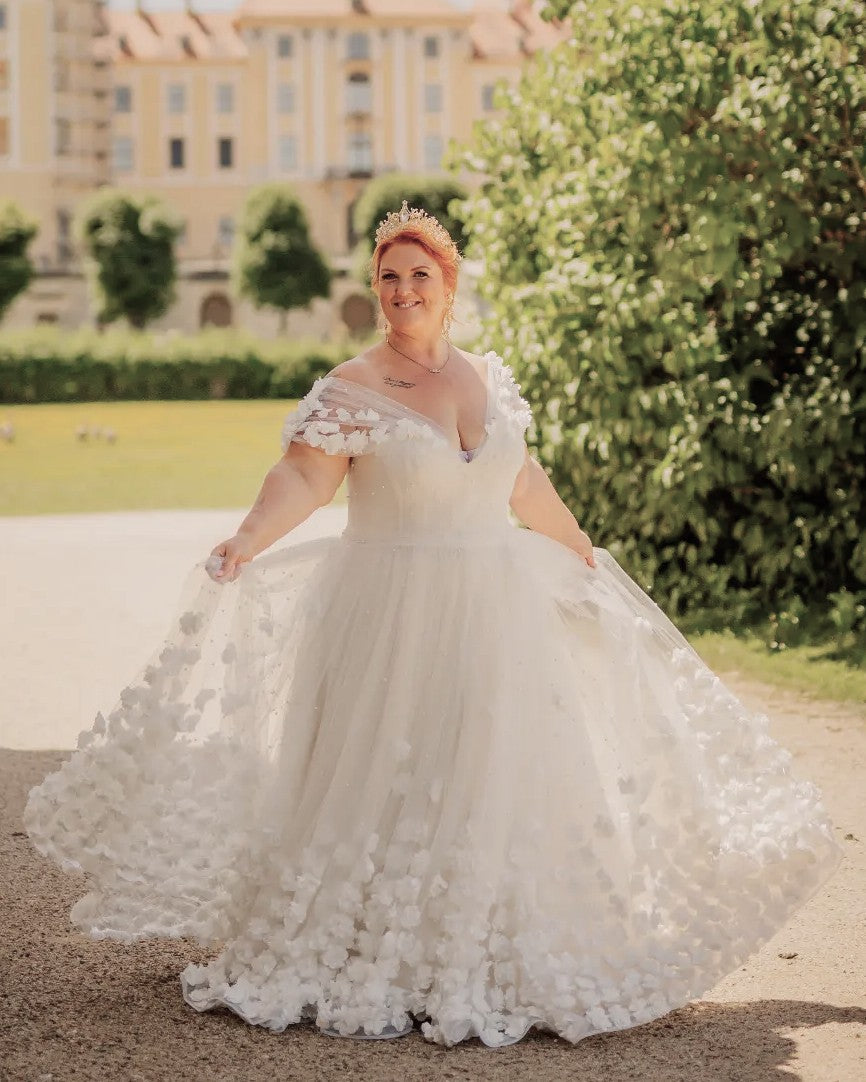 Plus-size bride in an off-shoulder A-line lace wedding dress in the garden