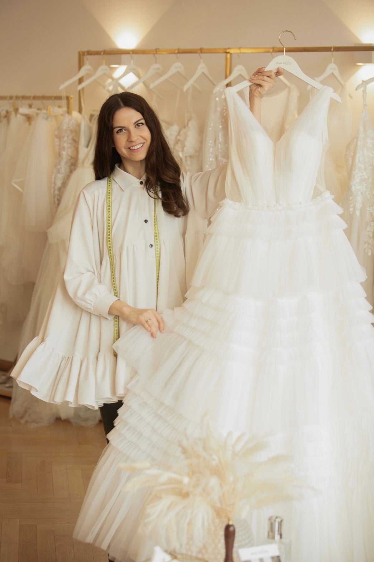 Designerin Jana Paulin neben einem Brautkleid mit Volantrock in ihrem Berliner Atelier