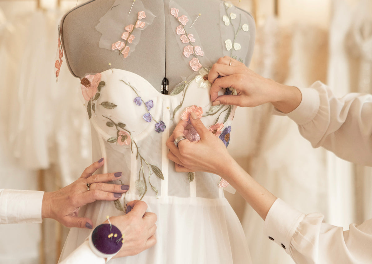 Seamstress pinning lace onto a wedding dress on the dress form – made to measure at Atelier Jana Paulin Berlin