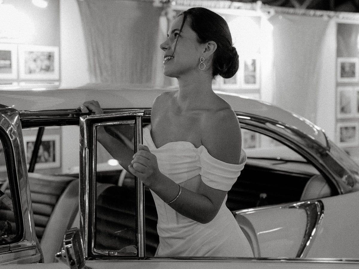Braut im modernen Brautkleid mit Puffärmeln im Oldtimer
